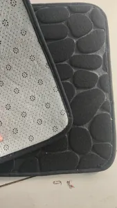 Close-up of black cobble texture coral fleece mat with 3D embossed nonslip backing