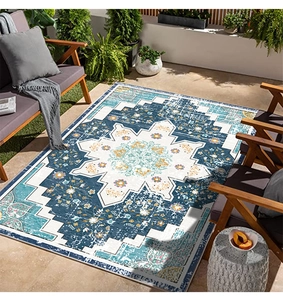 Close-up of a blue and white distressed Persian floral medallion outdoor patio rug