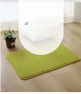 Close-up of grass green striped coral fleece bath mat with rounded edges on wood floor