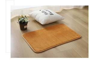 Detailed texture of orange coral fleece pet mat with stripe pattern on light wood floor