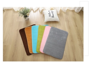 Detailed texture of colorful striped pebble coral fleece bathroom mats on wooden floor