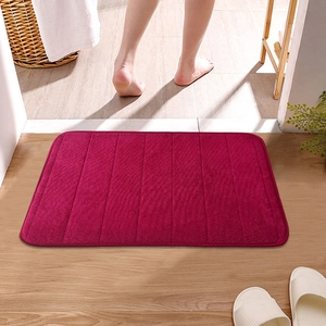 Burgundy striped coral fleece bathroom mat with absorbent texture on wood floor