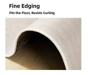 Detail of reinforced edge stitching and non-slip backing on a minimalist gray carpet