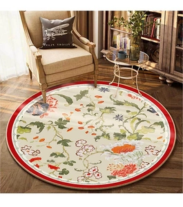 Close-up of vintage floral round rug with red border and botanical pattern on wood floor