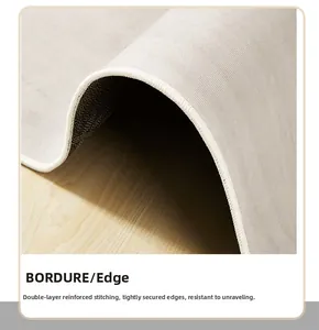 Close-up of high-density double-stitched reinforced edges on a minimalist light gray rug