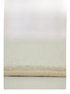 Gros plan des coutures de bordure denses sur un tapis en cachemire crème de luxe