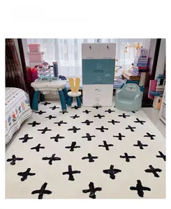 Détail d'un tapis doux crème à motifs de croix noires dans une chambre d'enfant moderne