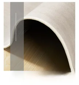 Détail du bord surjeté haute densité et envers antidérapant d'un tapis gris moderne