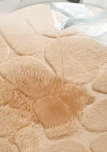 Macro shot showing rapid water absorption on pebble textured coral velvet bathroom mat
