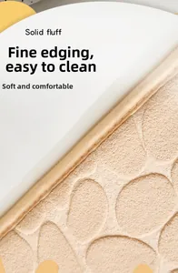 Detail of beige cobblestone embossed bath mat with fine edging and soft velvet texture