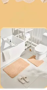 Close-up of orange cobblestone embossed coral fleece bathroom rug set with U-shaped toilet mat