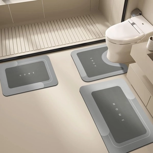 Three-piece absorbent bathroom mat set featuring grey geometric design and HOME print