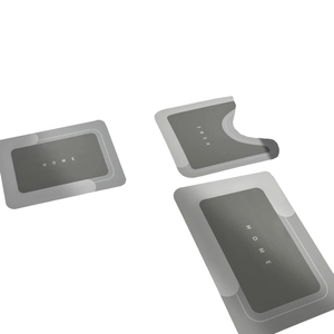 Three-piece absorbent bathroom mat set in grey with HOME lettering and geometric borders