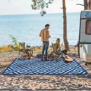 Blauw picknickkleed met ruitpatroon op een zandstrand voor camping en buitenactiviteiten