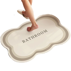 Absorbent diatom mud bath mat with scalloped edges and bathroom text on white background
