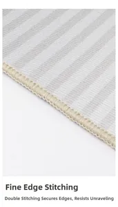 Close-up of minimalist gray striped rug showing dense reinforced overlock stitching detail