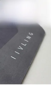 Close-up of a dark grey absorbent floor mat featuring smooth rounded edges and logo