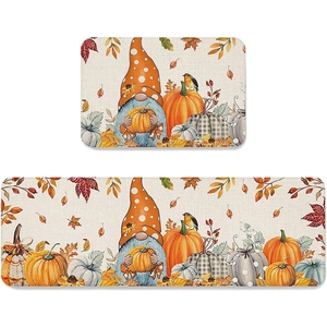 Detail of Harvest Gnome kitchen mat set featuring orange pumpkins and autumn leaves