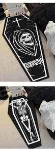 Detailed view of a coffin-shaped goth rug featuring a death skull and skeleton pattern
