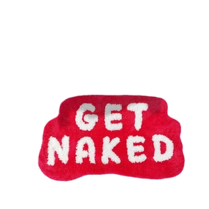 Absorbent red bath mat with Get Naked slogan and anti-slip wavy edges for bathroom
