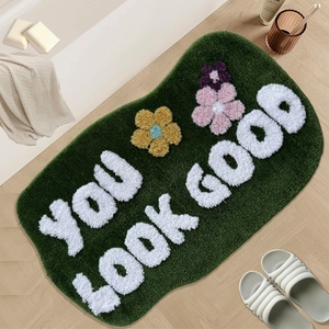 Absorbent plush bathroom mat with flower pattern and YOU LOOK GOOD text on wood floor