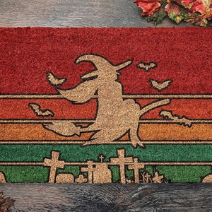 Halloween witch silhouette coir doormat on wooden floor with maple leaves decoration
