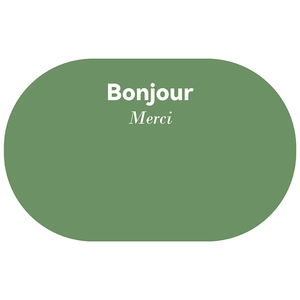 Detail view of oval green bath mat featuring Bonjour and Merci printed text