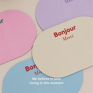 Minimalist absorbent bath mats in oval shapes with French Bonjour and Merci text prints