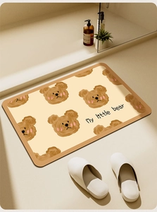 Detailed view of cream bath mat featuring cartoon bear patterns and anti-slip texture