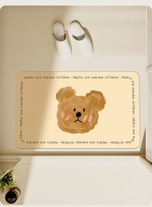 Close-up of beige bath mat with brown bear print and soft absorbent texture