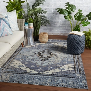 Close-up of bohemian distressed blue rectangular area rug on dark wood floor