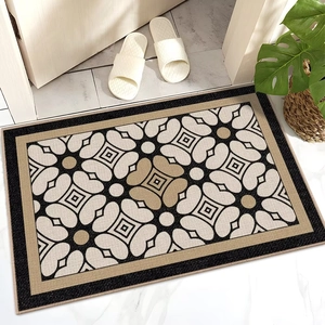 Detail view of French luxury doormat with geometric floral patterns on gray tile flooring
