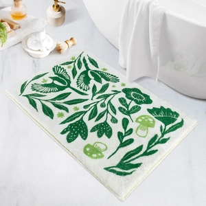 Saugfähige Blumen-Badematte mit grünen Waldmotiven neben einer weißen Badewanne