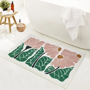 Detailaufnahme einer flauschigen Blumen-Badematte neben einer Badewanne auf Marmorboden