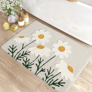 Detail der flauschigen Blumen-Badematte mit 3D-Gänseblümchen auf grauem Antirutsch-Stoff