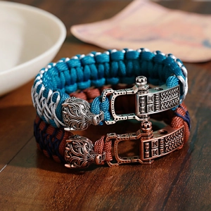 Detailed close-up of woven paracord bracelets with dragon head charms on a wooden surface