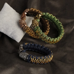 Detail of vintage braided paracord bracelets with skull and Indian chief charms on pillows