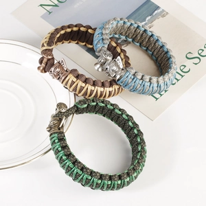 Detail of hand-woven thick cord bracelets with carved animal head metal shackles
