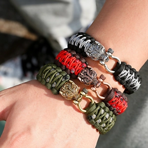 Nahaufnahme von Drachenkopf-Verschlüssen an gewebten Paracord-Armbändern