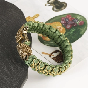 Detail of army green paracord bracelet with bronze skull tribal chieftain clasp