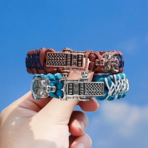 Close-up of woven paracord bracelet with Celtic knot clasp and carved wolf head detail