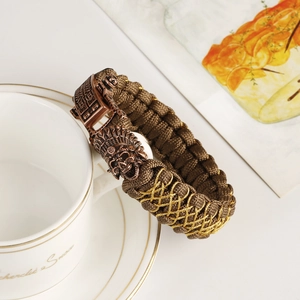 Macro shot of brown braided paracord bracelet with a vintage copper skull warrior clasp
