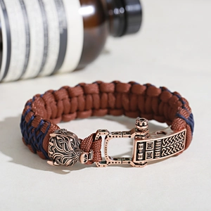 Detailed shot of a braided rope bracelet featuring a bronze wolf head metal clasp