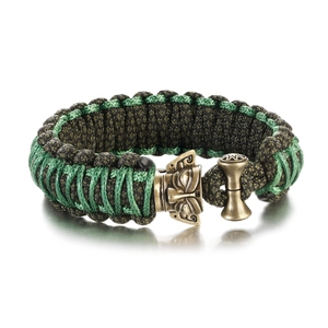Detail of hand-woven paracord bracelet featuring a bronze tribal mask buckle fastener