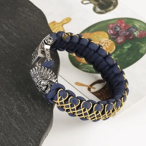 Detailed macro view of the vintage skull chief buckle on a braided navy blue paracord bracelet