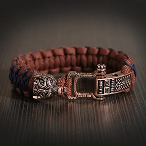 Close-up of wolf head bronze buckle and woven paracord on men's adjustable bracelet