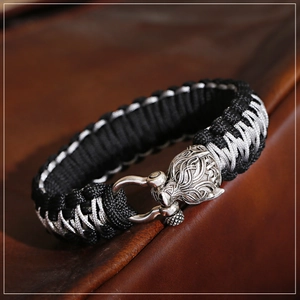 Makroaufnahme von geflochtenem Paracord-Armband mit Wolfskopf und Edelstahl-U-Verschluss