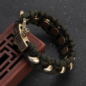 Detail eines armee-grünen Paracord-Armbands mit Vintage-Messing-Spikes und Zirkonia-Steinen