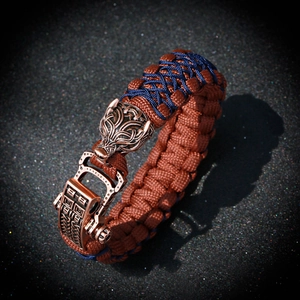 Detail of paracord bracelet with bronze wolf head and decorative metal clasp