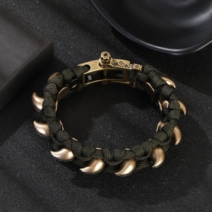 Detail eines armee-grünen Paracord-Armbands mit Bronze-Nieten und Metallschnalle
